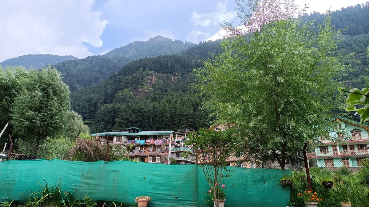 Hotel Seraj International with mountain backdrop in Manali